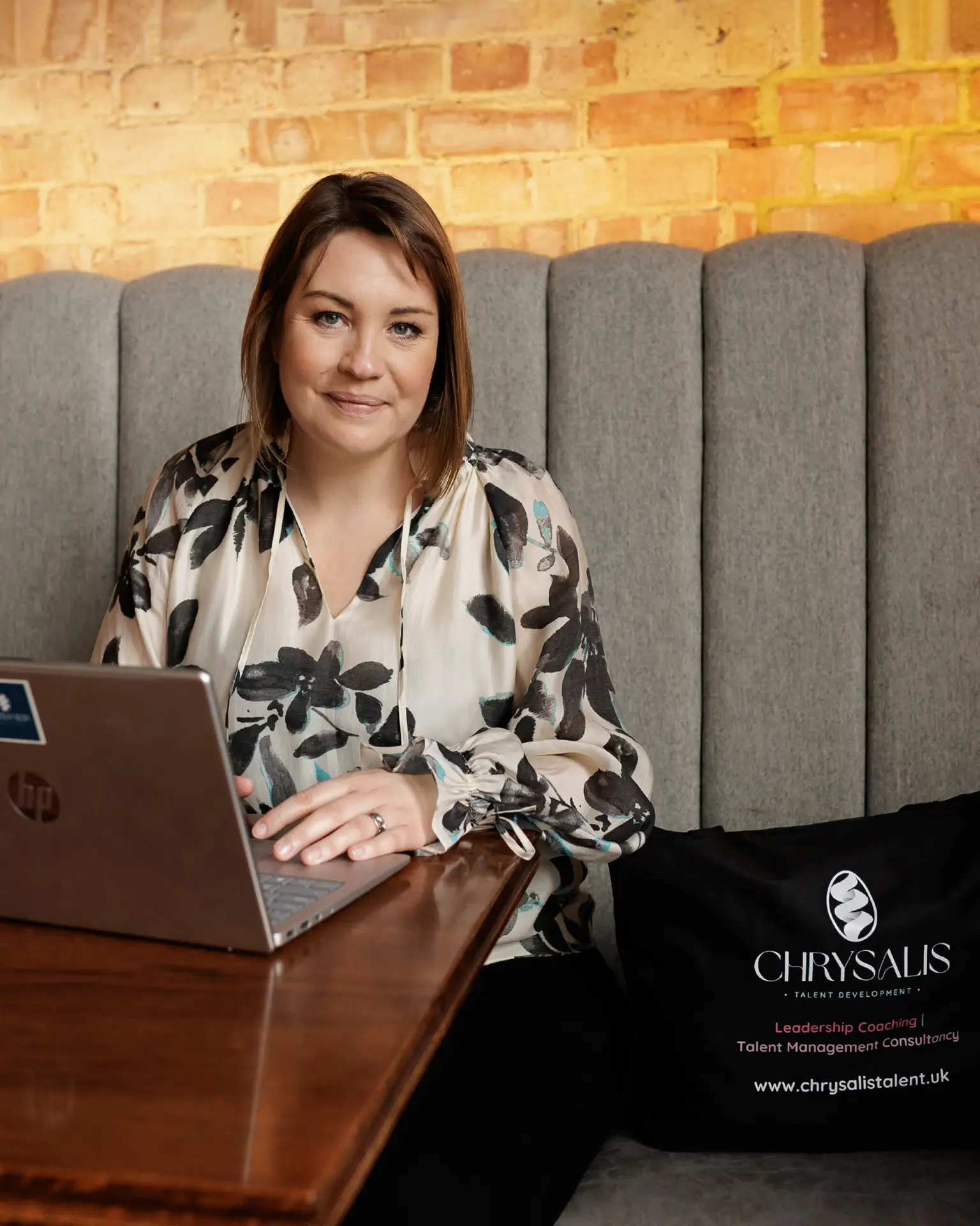 Verity Stainsby working on a laptop beside a Chrysalis Talent Development bag