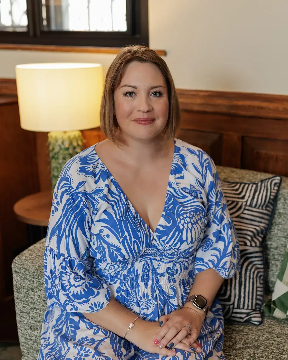 Verity Stainsby seated in a blue patterned dress